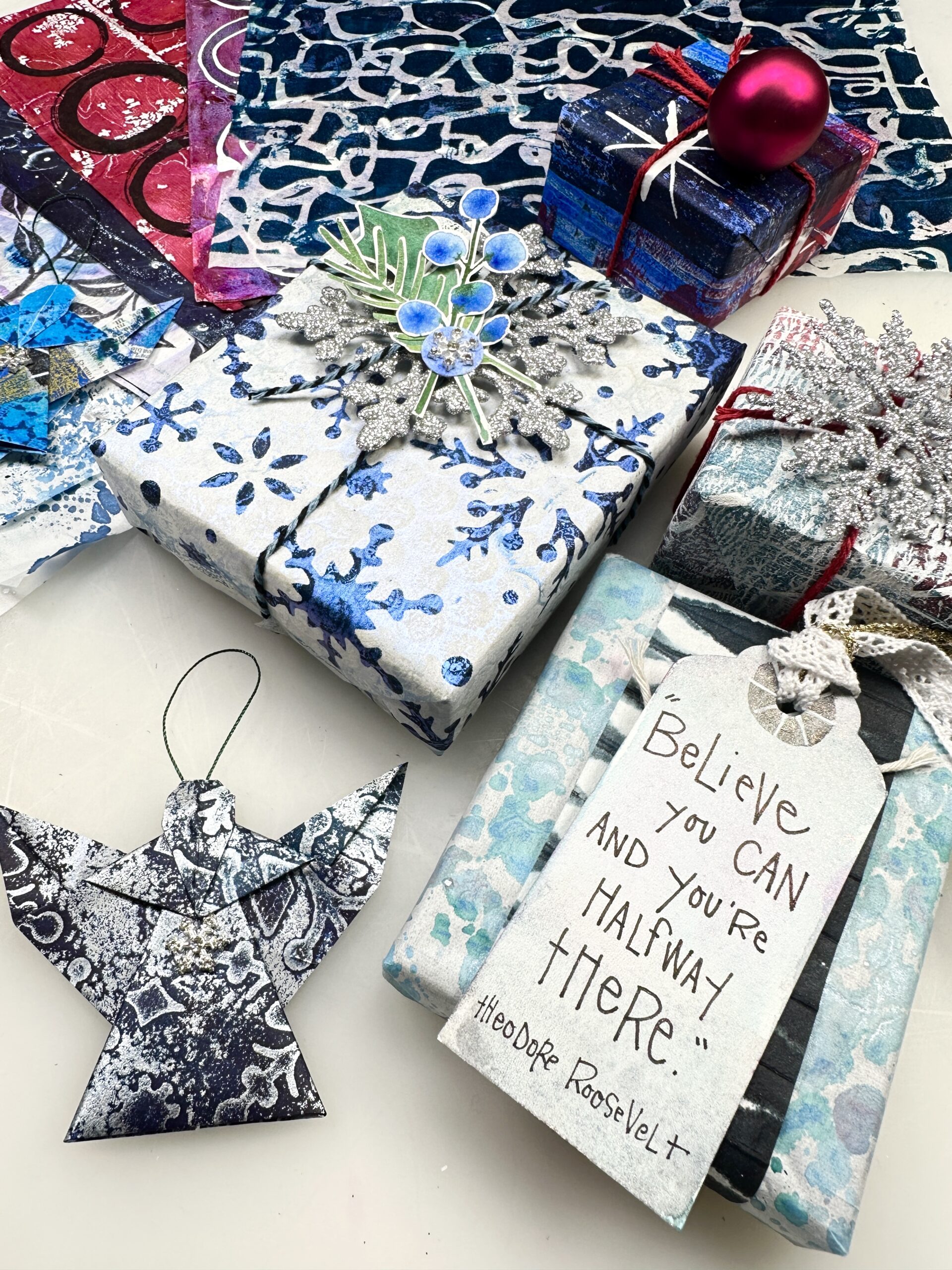 gift wrapped boxes, tags, and origami angel made out of embellished washi paper