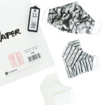 three origami face masks with abstract ink designs and a bottle of sumi ink and washi paper pad to the side