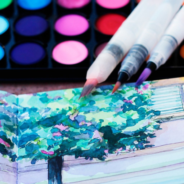 KWBV2 Niji Waterbrush Value Set brushes on top of watercolor palette and watercolor tree