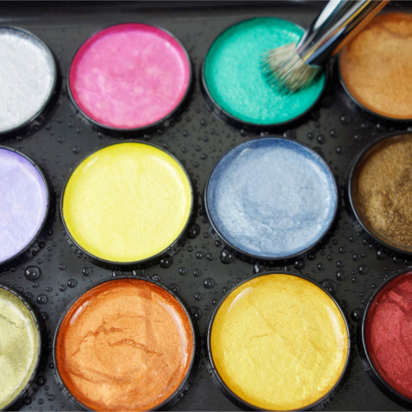 Stencil brush picking up color from pearlescent watercolor cakes