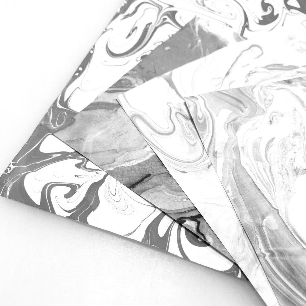 four stacked sheets of Gasen paper with black and white suminagashi, or Japanese ink marbling