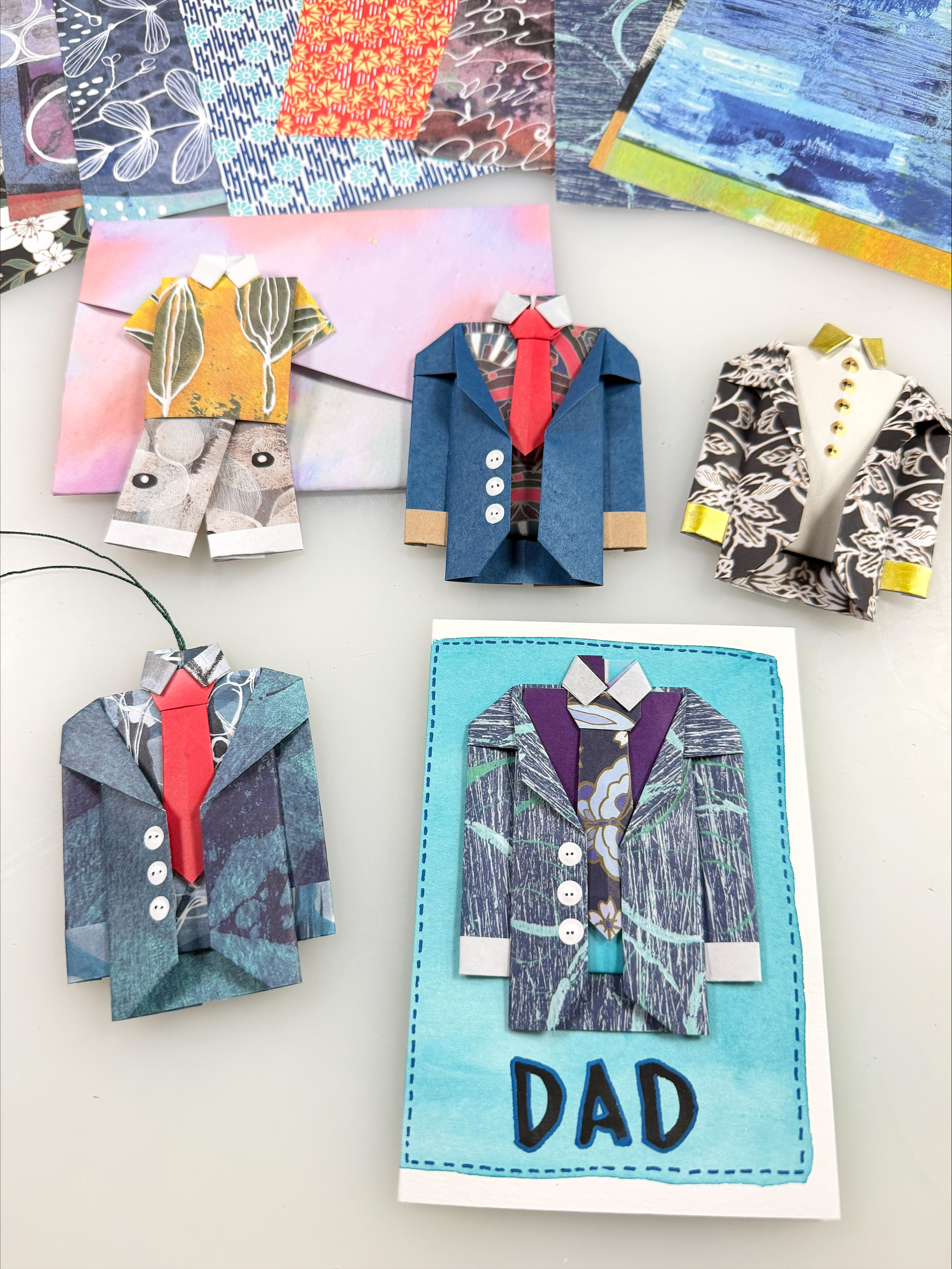 colorful origami suits with ties and a handmade father's day card in the foreground