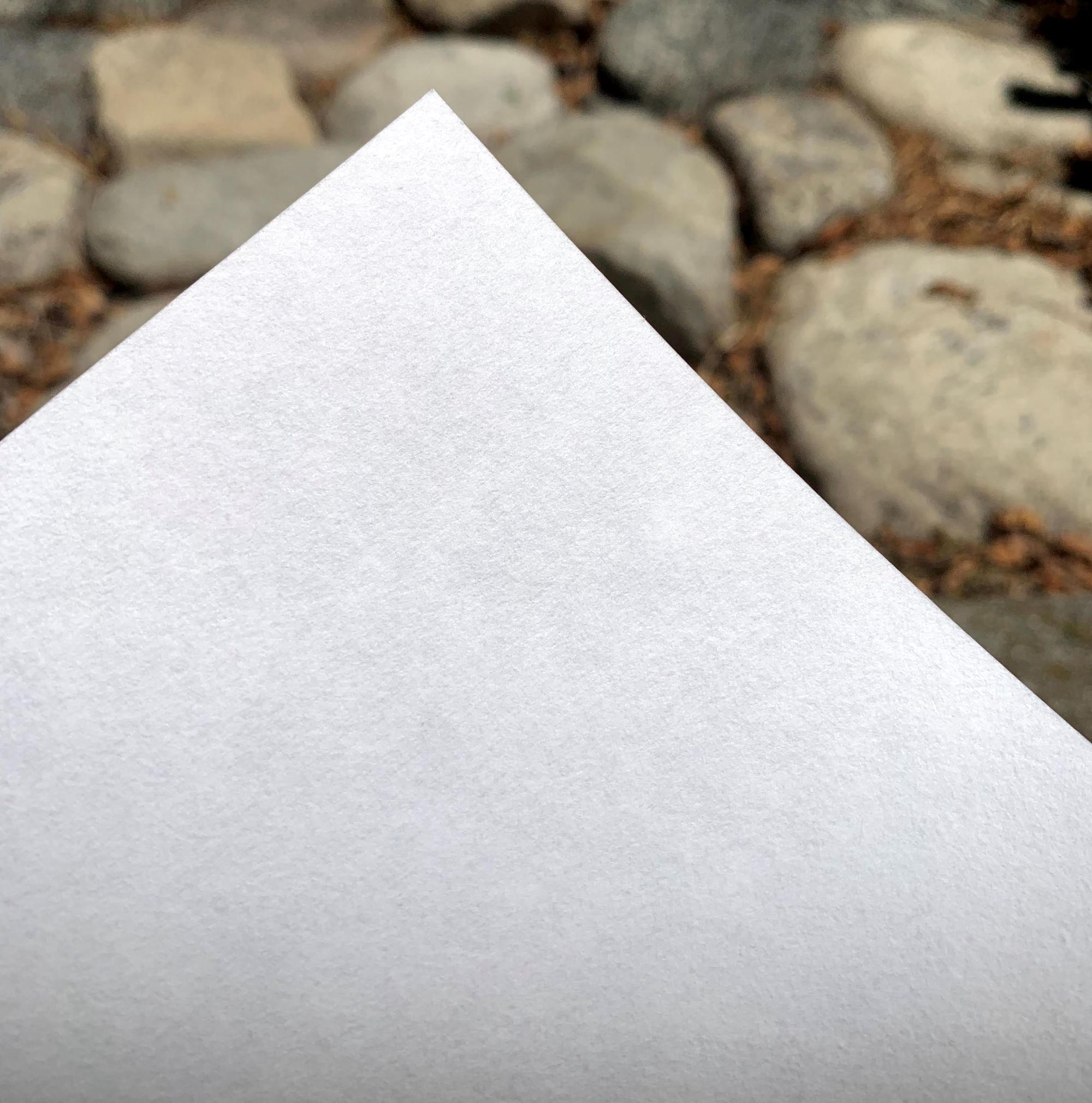 close up picture of the corner of a sheet of Torinoko paper against a background of rocks
