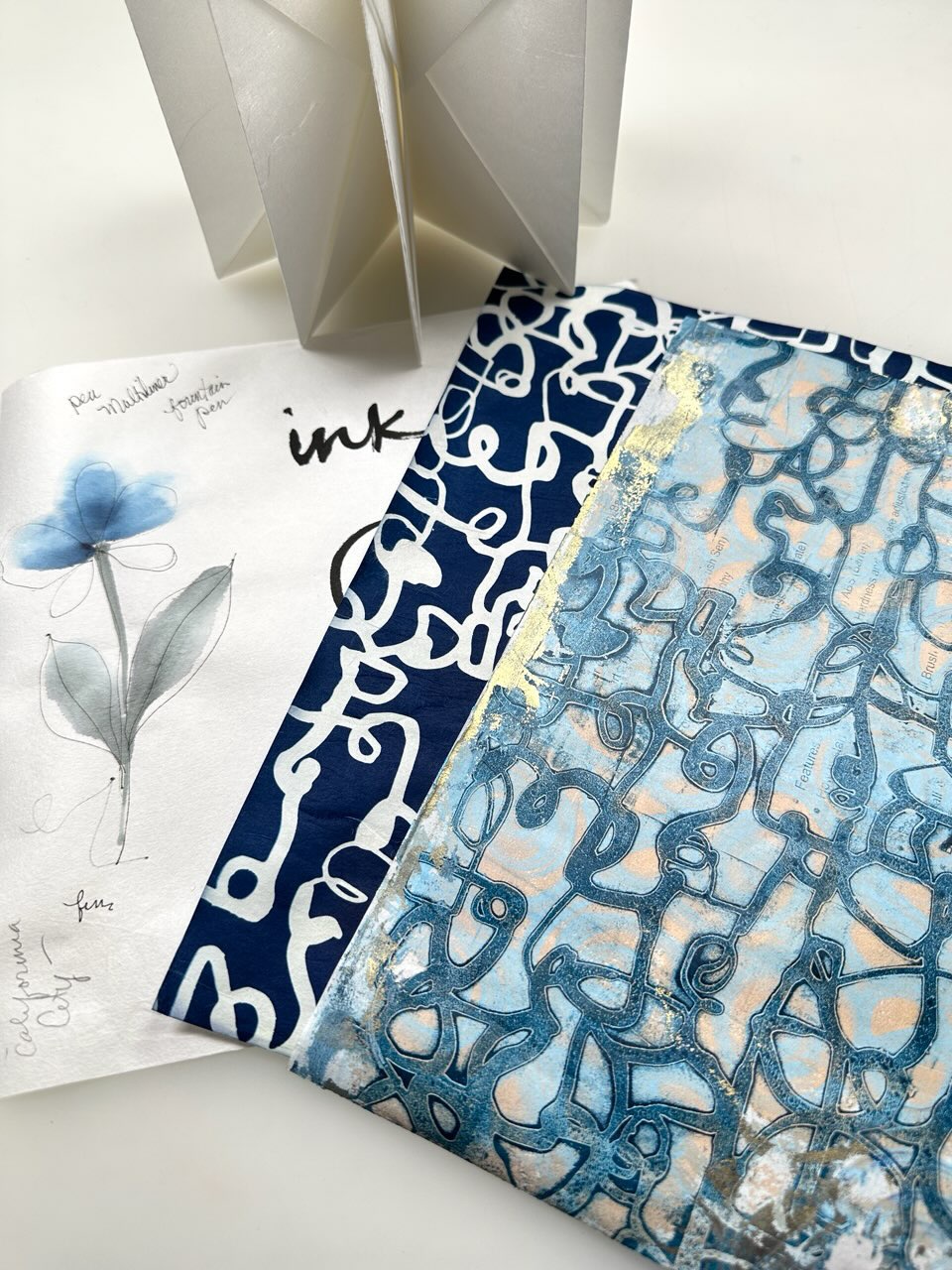 spread of gel print, cyanotype, gansai painting, and origami blizzard book made with Unryu paper