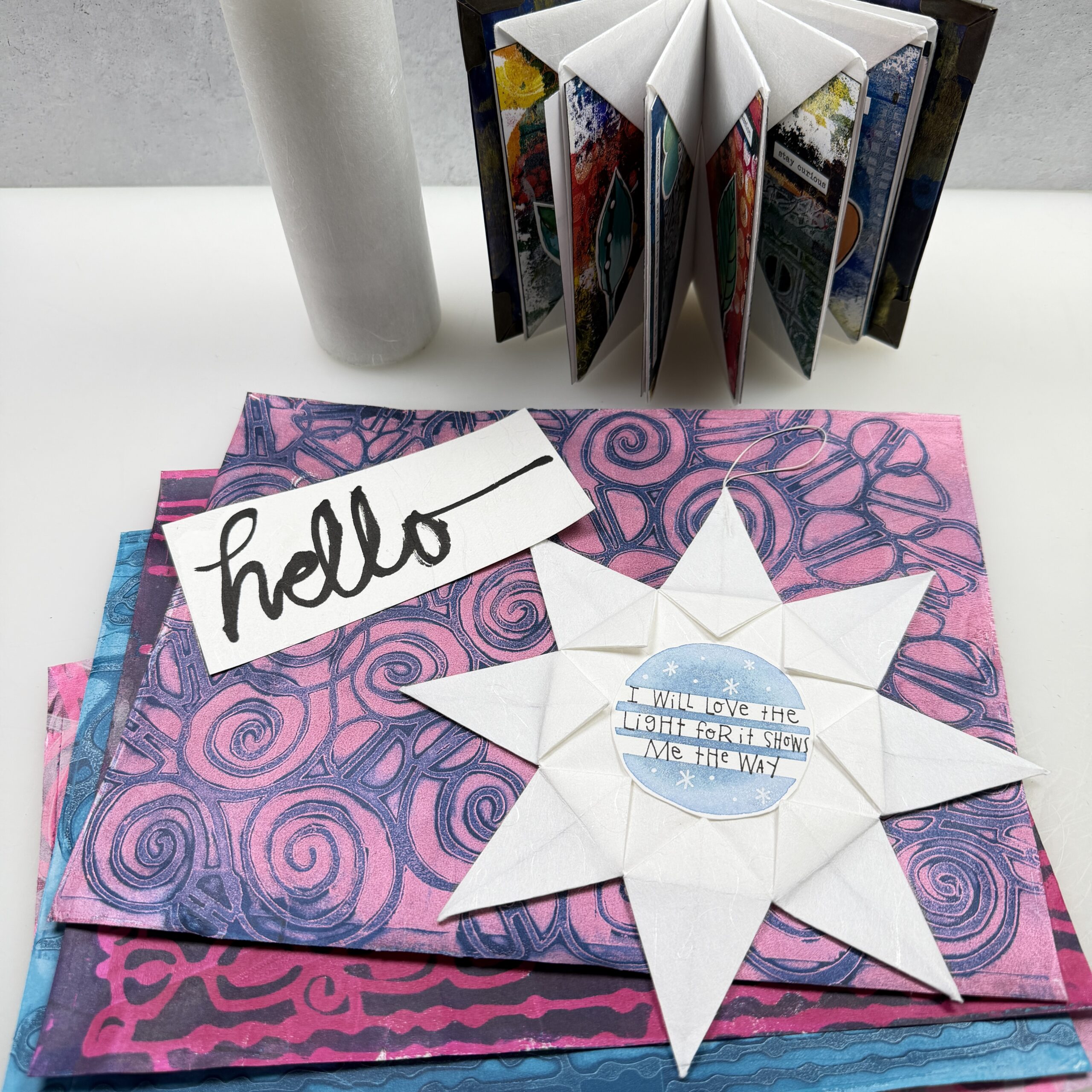 origami star on top of colorful gel printed Unryu washi paper with an Unryu roll and origami book in the background