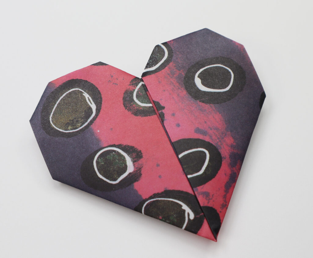 origami heart made out of red and purple dotted paper