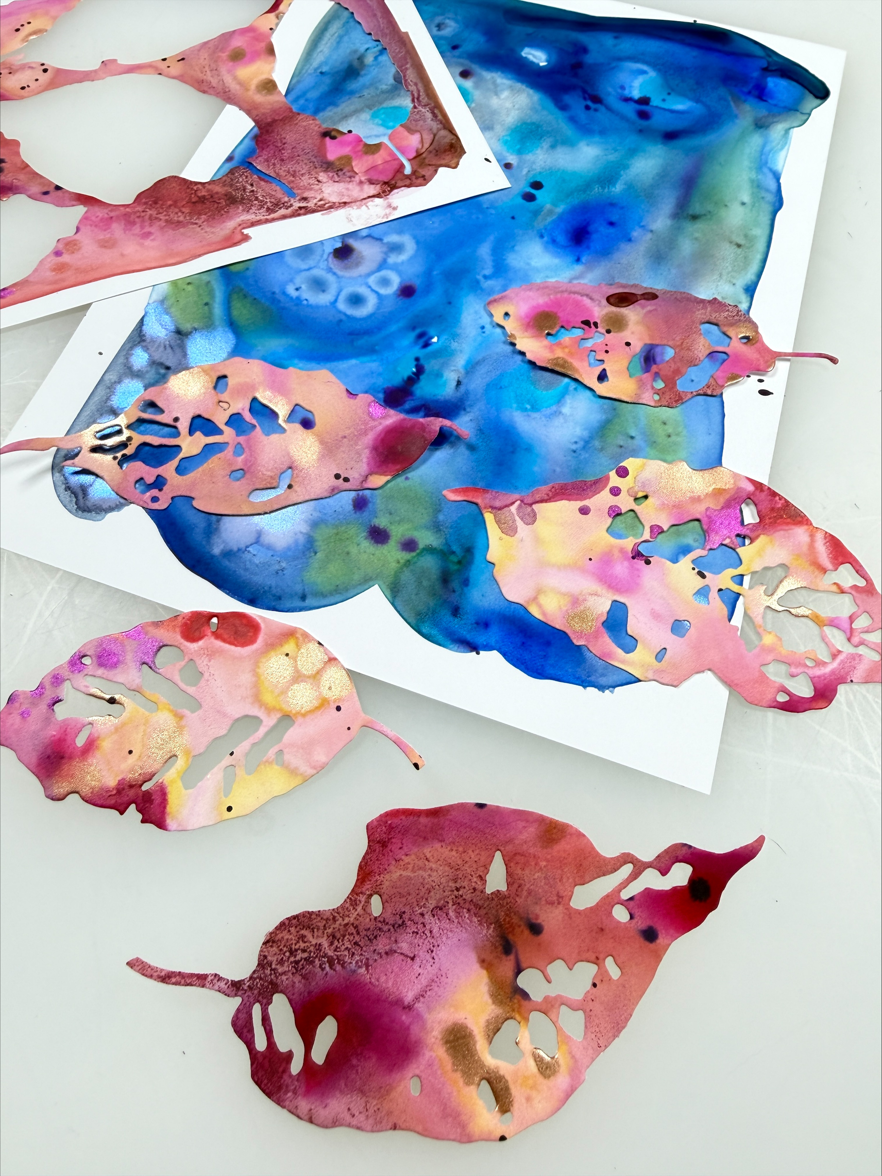 abstract colored mineral paper paintings and die cut paper leaves