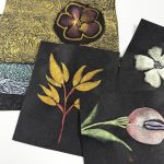 metallic florals painted on black washi paper with a stack of metallic brushed momigami sheets in the background