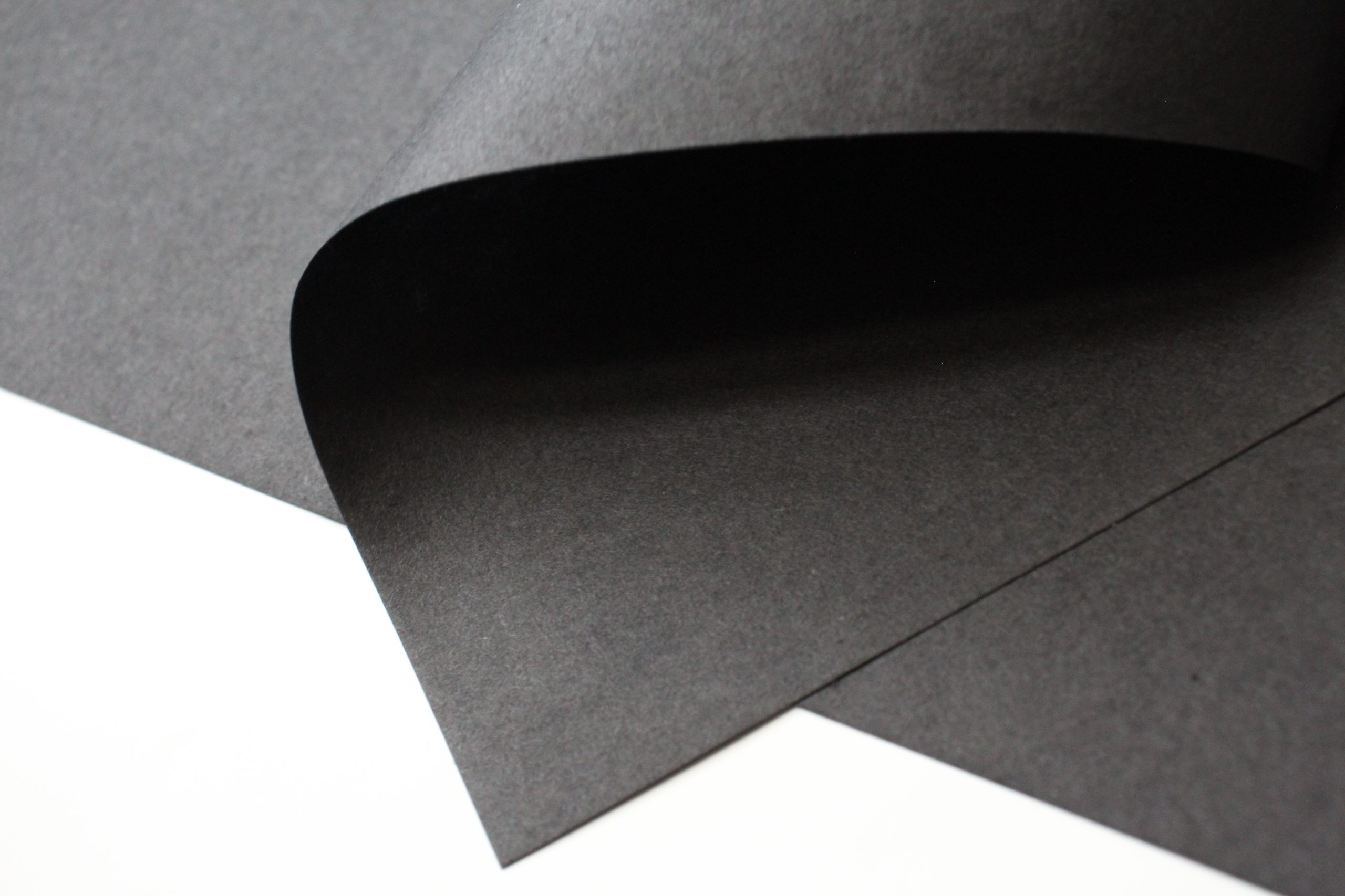 close up picture of black washi paper curved to show texture