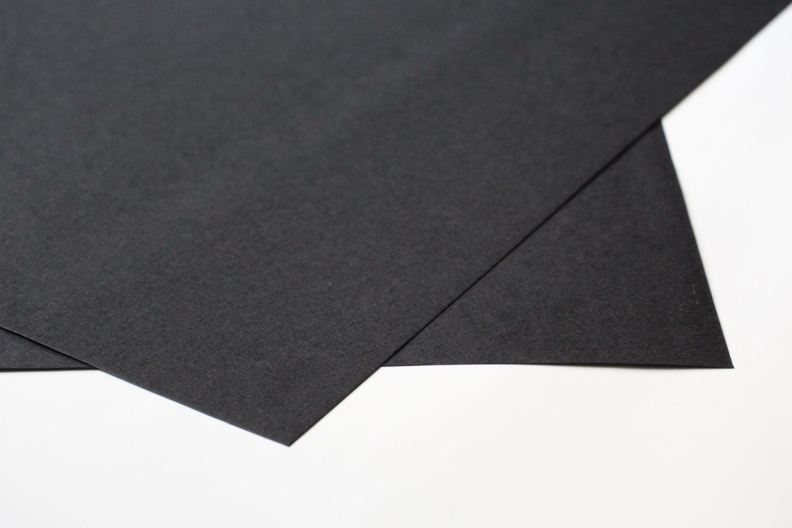 close up picture of the corners of two sheets of black washi paper