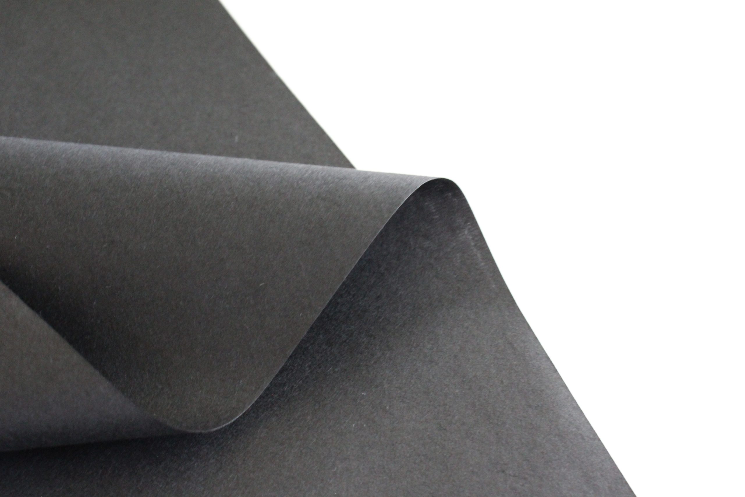 close up picture of black washi paper curved to show texture