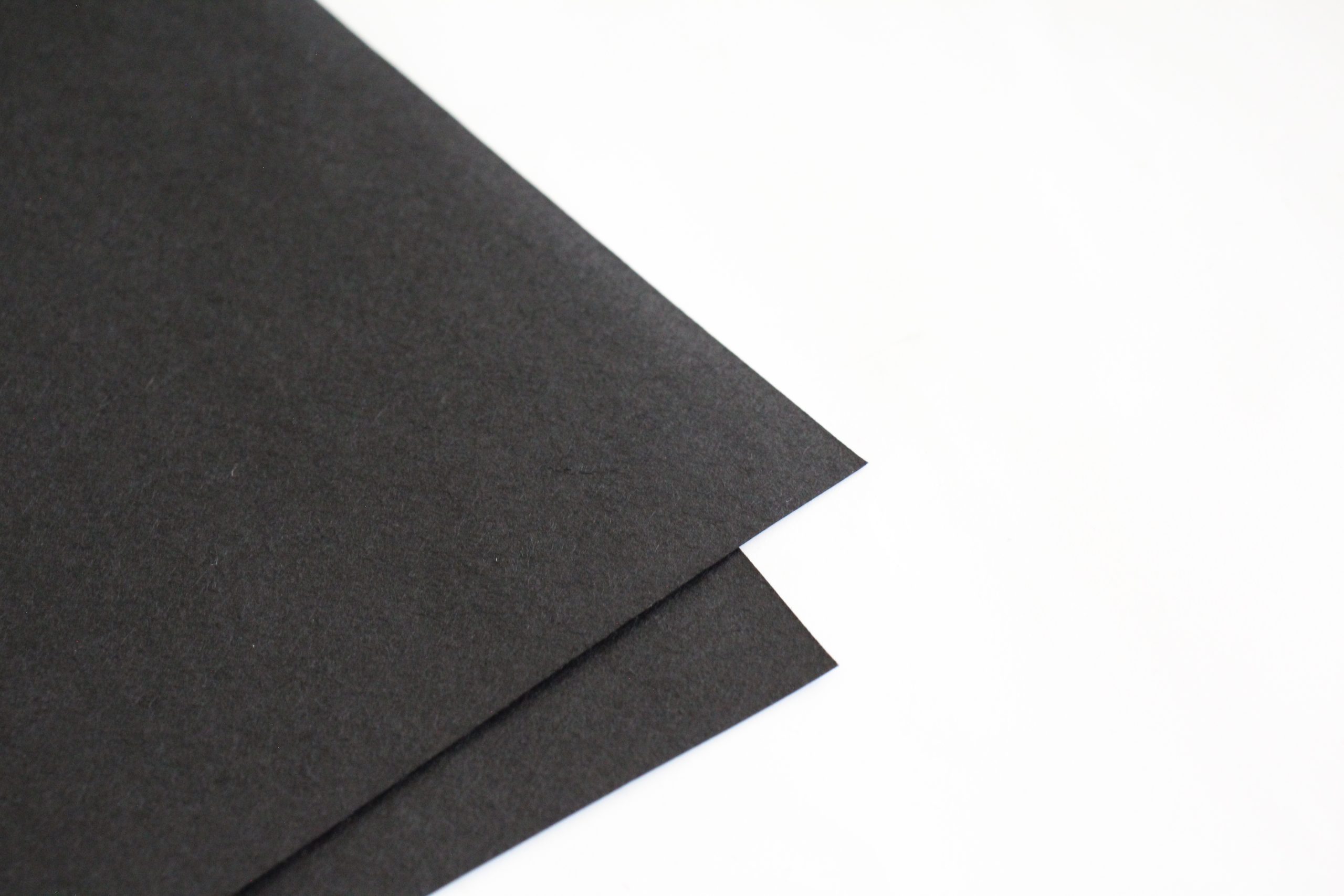 close up picture of the corners of two sheets of black washi paper