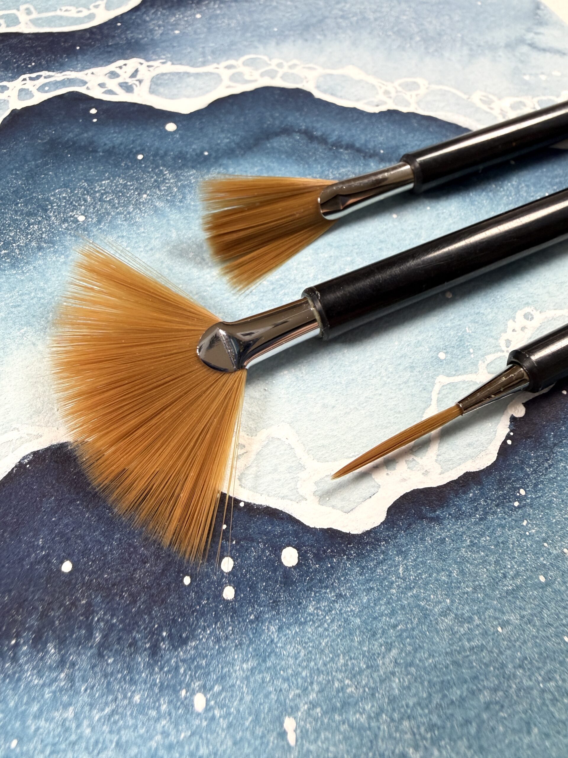 fanned and liner fusion brushes on top of watercolor ocean waves