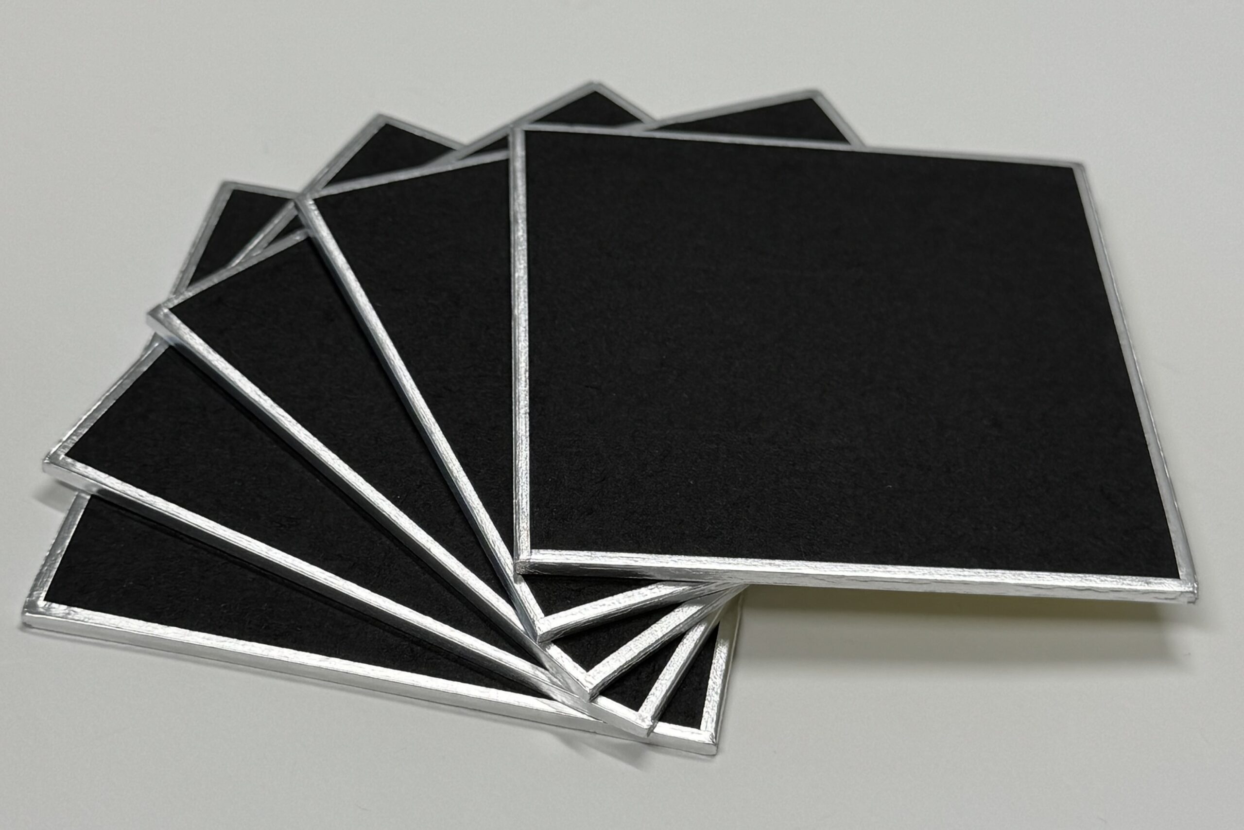 angled photo of five black shikishi board stacked and fanned out
