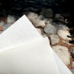close up of two sheets of Kozo paper with rocks in the background