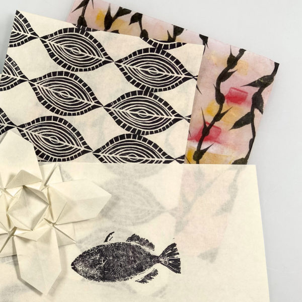 stack of Mashi paper artwork, including fish print, origami, monoprinting and encaustic pieces